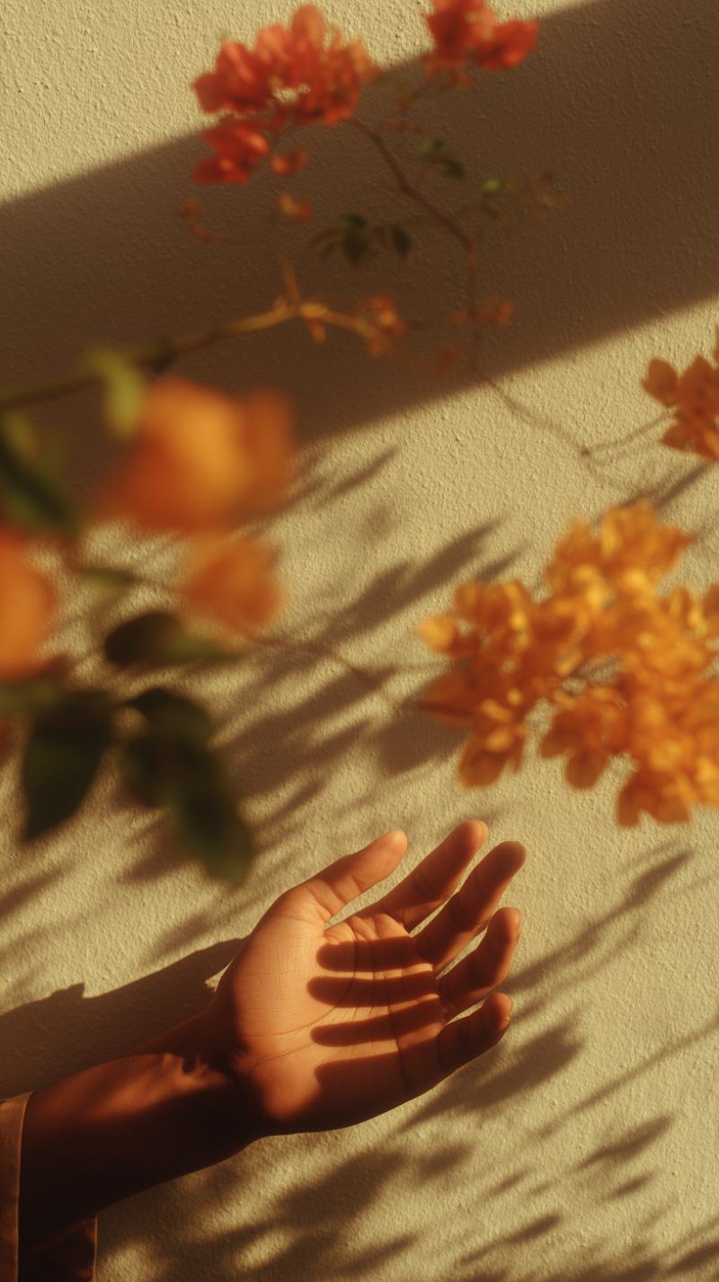 Hand in golden hour light with flower shadows