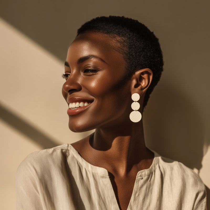 Smiling woman in warm light with statement earrings